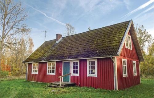 a red house with a black roof and white windows at Four-Bedroom Holiday Home In Killeberg in Killeberg