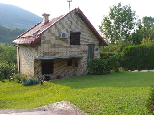 a house with a grass yard with a house at Holiday Home Zbilje in Visoko
