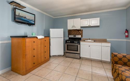 a kitchen with a white refrigerator and a stove at Boardwalk Hotel Charlee & Apartments Beach Hotel Oceanfront in Seaside Heights