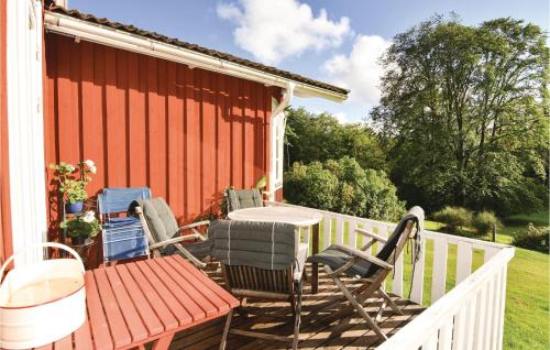 a deck with a table and chairs on a house at 4 Bedroom Stunning Home In Färgelanda in Färgelanda