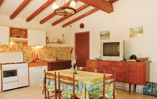 a kitchen with a table and a tv and a table and chairs at 2 Bedroom Awesome Home In Teyssieres in Teyssières