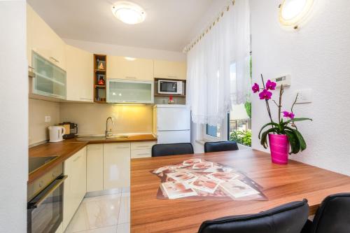 a kitchen with a wooden table with chairs and a dining room at Apartmani Katica in Povile