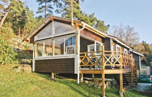 a tiny house with a large porch and windows at Rodebo in Ljungskile