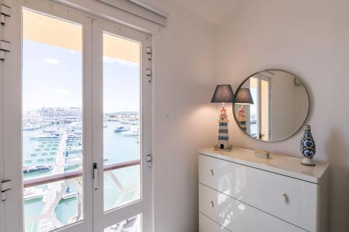 a room with a mirror and a dresser and a window at LovelyStay - Two Bedroom Duplex at Vilamoura Marina in Vilamoura
