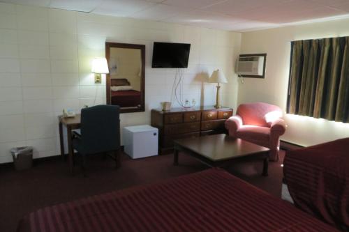 a hotel room with a bed and a chair and a desk at Grand Inn Fargo in Fargo