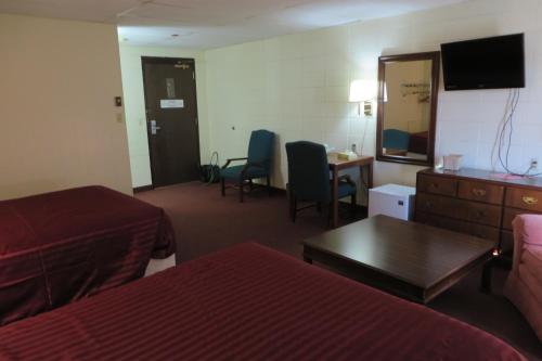 Habitación de hotel con 1 dormitorio con 2 camas y escritorio. en Grand Inn Fargo en Fargo