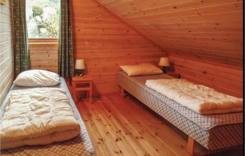 1 Schlafzimmer mit 2 Betten in einem Blockhaus in der Unterkunft Gorgeous Home In Lindesnes With House Sea View in Jåsund
