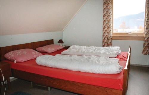 a bedroom with two beds with white sheets and pink pillows at Solhaug in Fresvik