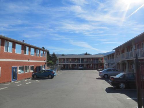 a parking lot with cars parked in front of buildings at Cactus Tree Inn in Oliver