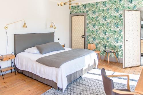 een slaapkamer met een bed en een groene muur bij L'esprit du 8 in Rochefort