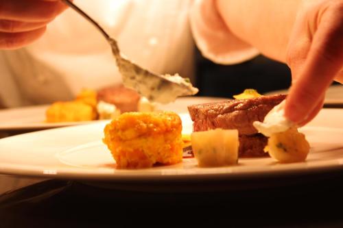 a person is eating food on a plate at Hotel Restaurant Am Kring in Vreden