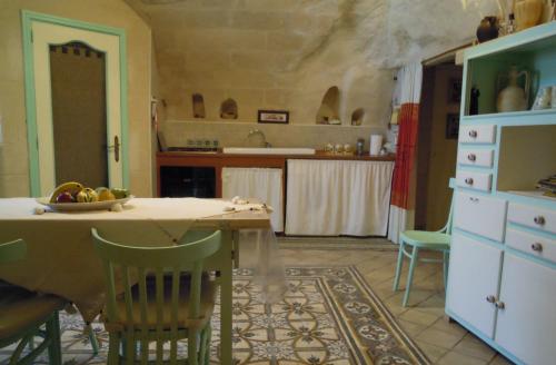 a kitchen with a table and some chairs and a counter at Casa Contini in Matera