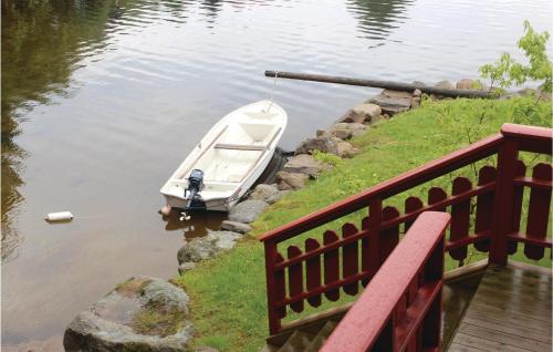 a small boat in the water next to a dock at Amazing Home In Farsund With House Sea View in Lindland