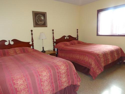 a bedroom with two beds and a window at Happy Motel in Edmundston