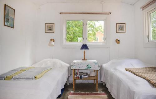 2 camas en una habitación con mesa y ventana en Beautiful Home In Nssj With Kitchen, en Nässjö