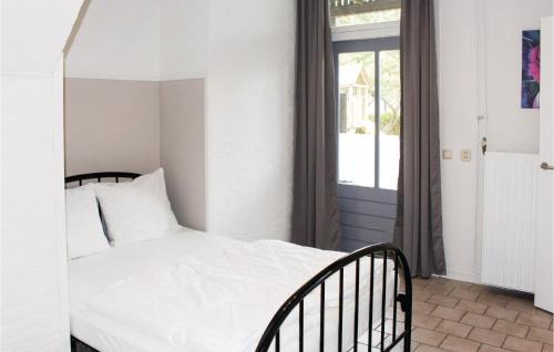 Schlafzimmer mit einem weißen Bett und einem Fenster in der Unterkunft Appartement 1 - De Eekhof in Hindeloopen