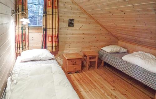 a bedroom with two beds in a log cabin at Stunning Home In Lindesnes With Sauna in Jåsund