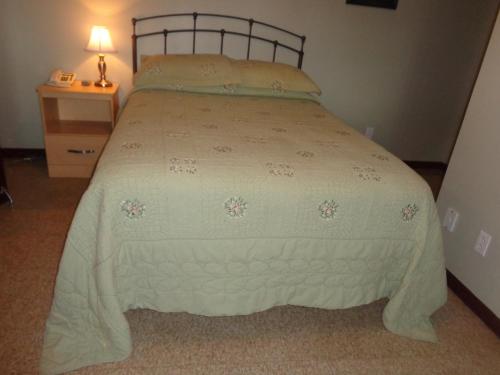 a bedroom with a bed with a white comforter at Happy Motel in Edmundston
