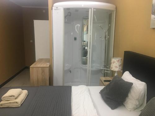 a bedroom with a shower and a bed with towels at Royal Apartments & Rooms in Zagreb