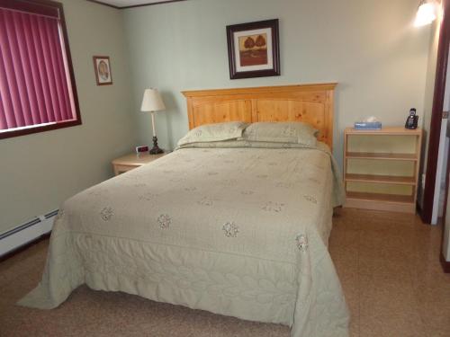 a bedroom with a large bed with a wooden headboard at Happy Motel in Edmundston