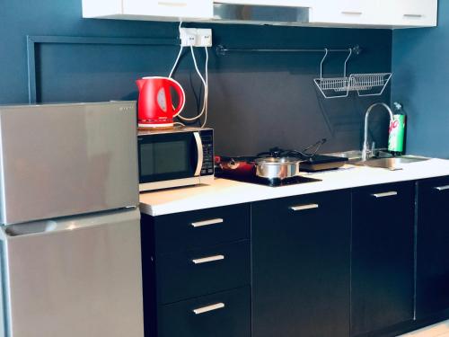 a small kitchen with a microwave and a stove at Scott Garden - Mid Valley by Leisure2U - Cheap stay, check in out time and price negotiable in Kuala Lumpur