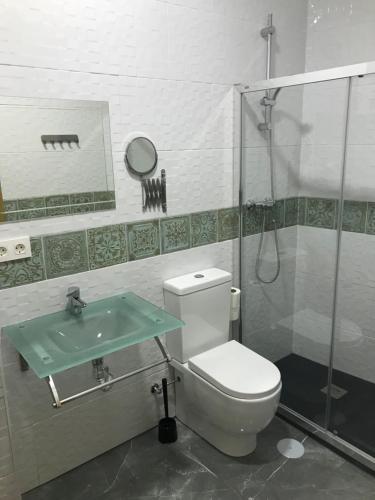 uma casa de banho com um WC, um chuveiro e um lavatório. em Hostal Kavanna em San Pedro de Mérida