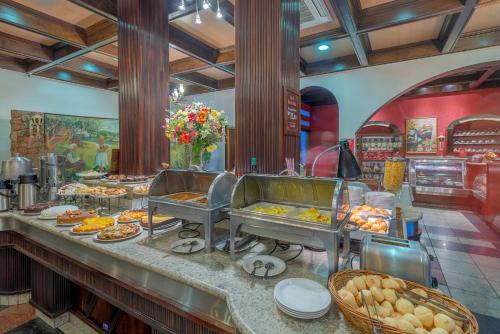 a buffet line with food on display in a restaurant at Hotel Glória Blumenau in Blumenau