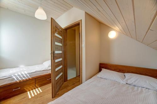 ソリナにあるDomki Przy Zaporzeのベッドルーム1室(ベッド2台付)、開閉ドアが備わります。