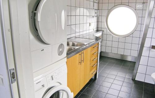 a small bathroom with a sink and a washing machine at Nice Home In Mnsarp With Kitchen in Bondstorp