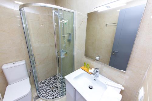 a bathroom with a shower and a sink and a toilet at Santa Oliva Suites in Ksamil