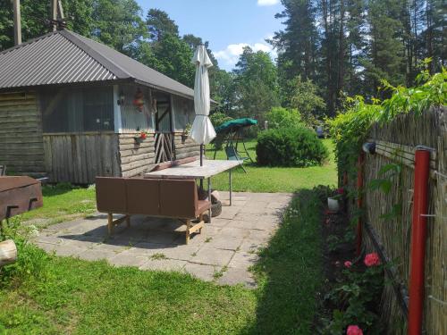 a patio with a table and an umbrella in a yard at White House puhkemaja in Uulu