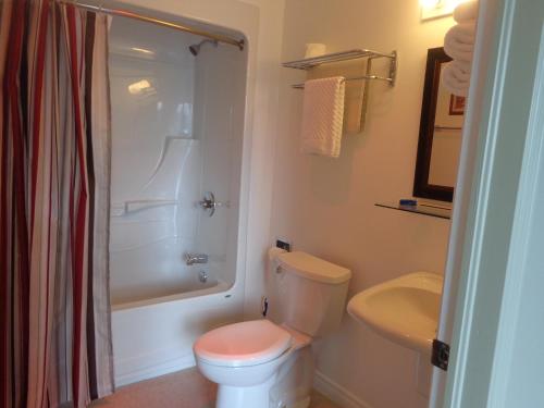 a bathroom with a white toilet and a sink at Happy Motel in Edmundston
