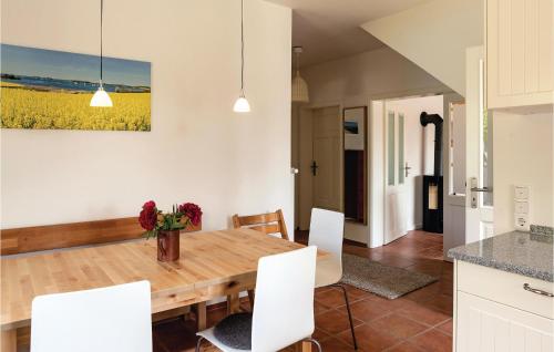 a kitchen and dining room with a wooden table and white chairs at Lovely Home In Gammelby With Kitchen in Gammelby