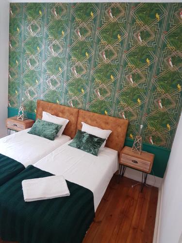 two beds in a room with a green wall at Monte Agudo Angola 45 in Lisbon