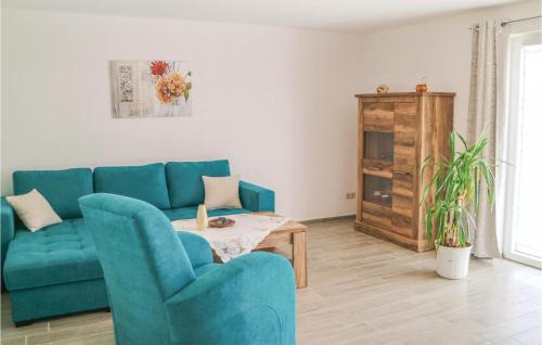 Una sala de estar con un sofá azul y una mesa. en 2 Bedroom Awesome Home In Zingst, en Zingst
