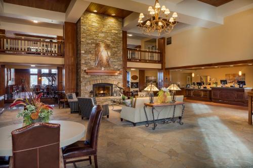 uma ampla sala de estar com uma lareira de pedra e um lustre em Running Y Ranch Golf & Spa Resort em Klamath Falls