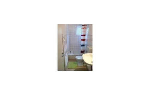 ein Bad mit einem roten und weißen Streifen an der Wand in der Unterkunft Ferienhaus Seeigel J in Süssau