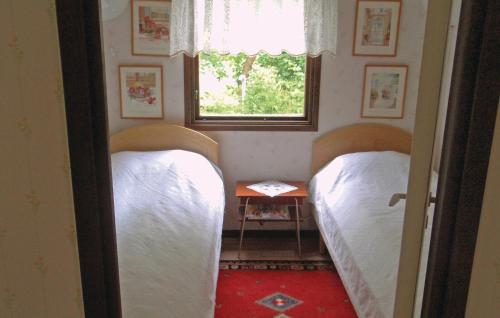 two beds in a small room with a window at Two-Bedroom Holiday Home In Solvesborg in Sölvesborg