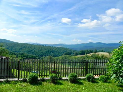 a fence with mountains in the background at Holiday Home Captain's Village in Šljivovica
