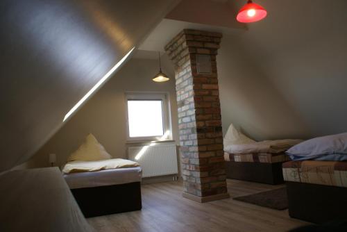 UmmanzにあるBauer Langeのベッド2台と窓が備わる屋根裏部屋です。