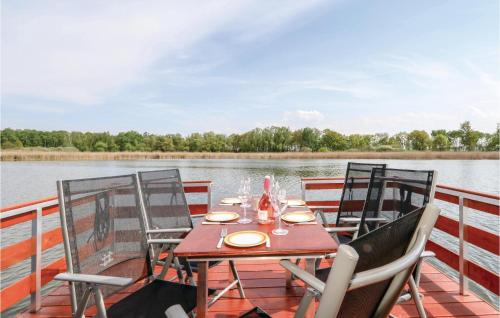 a table and chairs on the deck of a boat at Cozy Ship In Neustrelitz With Wifi in Neustrelitz