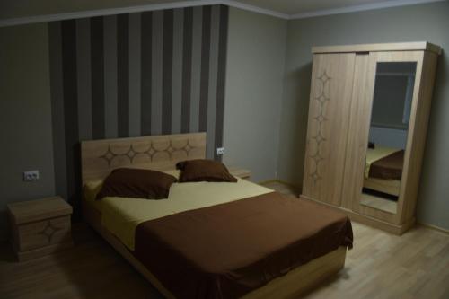 a bedroom with a large bed and a mirror at gogoli family hotel in Tbilisi City