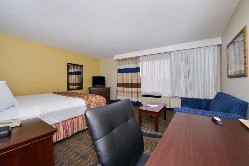 a hotel room with a bed and a desk at Lamplighter Inn-South in Springfield