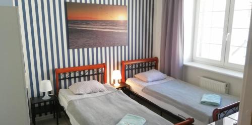a room with two beds and a picture of the ocean at Great Polonia Beach & Molo in Puck