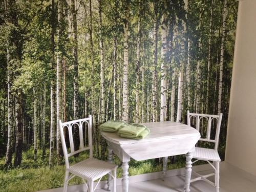 Saint-Sauveur的住宿－Les Chambres de KERCHELGEN，森林壁画前的一张桌子和两把椅子