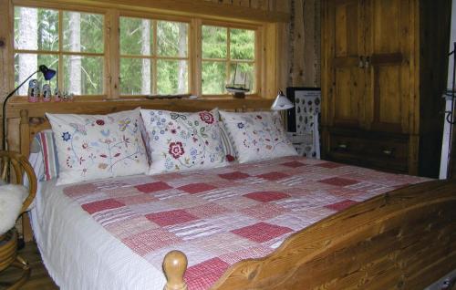 a bedroom with a wooden bed with pillows at 2 Bedroom Awesome Home In Lnghem in Åkra