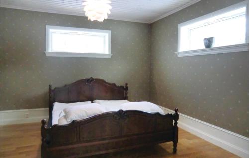 a bedroom with a bed and two windows at Lovely Home In Tranås With Kitchen in Bjärsjö