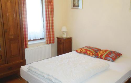 un letto bianco con due cuscini in una camera da letto di Appartment C a Haut-Fays
