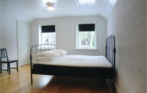 a bedroom with a bed with white sheets and a window at Lovely Home In Tranås With Kitchen in Bjärsjö