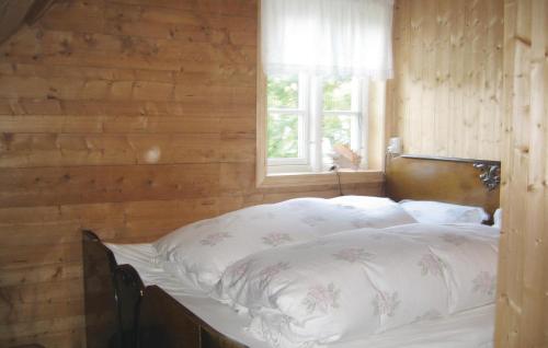 Ce lit se trouve dans une chambre en bois dotée d'une fenêtre. dans l'établissement Nice Home In Manger With House Sea View, à Manger